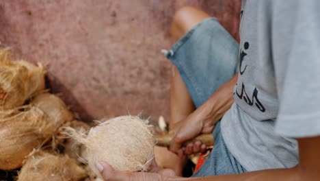 Close-Up-Shot-of-Young-Mans-Hands-Shaving-Coconut-Coir-Fibre-