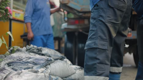Close-Up-Shot-of-Workers-Hands-Loading-Bags-into-Truck