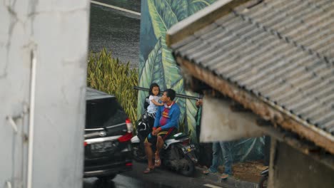 Long-Shot-of-Man-and-Small-Child-Sitting-In-Rain