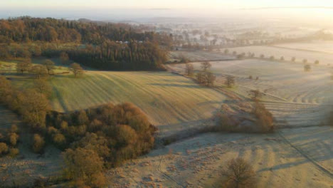 Drone-Shot-of-a-Vast-Misty-Rural-Landscape-During-Sunrise