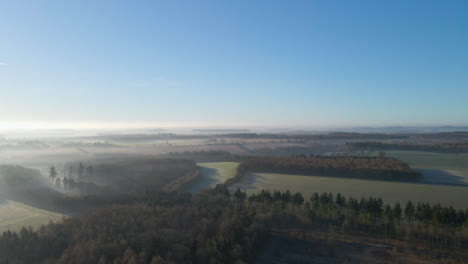 Drohnenschwenk-Einer-Weiten,-Nebligen-Landschaft-Bei-Sonnenaufgang