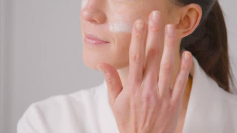 Close-Up-Shot-of-Young-Woman-Applying-Cream