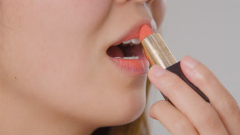 Close-Up-Shot-of-Young-Woman-Applying-Lipstick