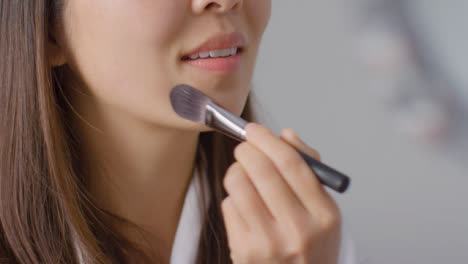 Close-Up-Shot-of-Woman-Applying-Foundation-and-Smiling