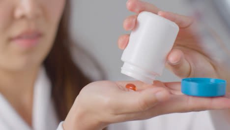 Close-Up-Shot-of-a-Woman-Pouring-Pills-into-Her-Hand