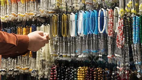 Mid-Shot-of-Man-Looking-at-Beads