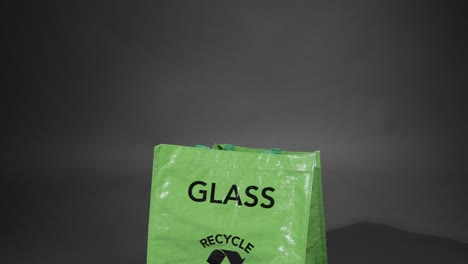 Medium-Shot-of-Glass-Bottle-Being-Placed-In-Recycling-Bag