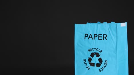 Medium-Shot-of-Paper-Being-Placed-In-Recycling-Bag