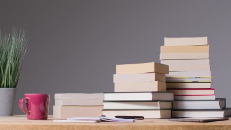 Stop-Motion-Shot-of-Books-Piling-Up-On-Desk