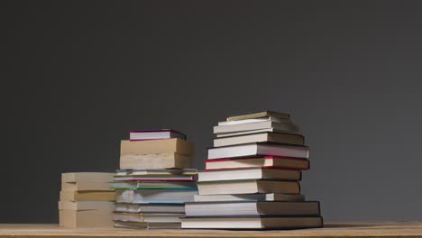 Stop-Motion-Shot-of-Piles-of-Books-On-a-Table