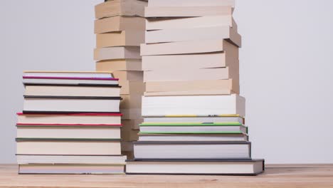 Stop-Motion-Shot-of-Several-Piles-of-Books-On-Table