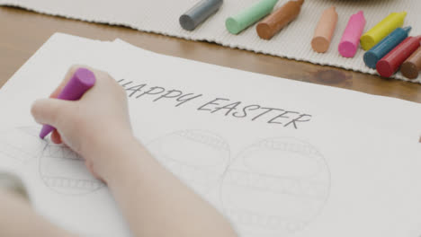 Tracking-Shot-of-a-Young-Girl-Colouring-In-an-Easter-Themed-Drawing