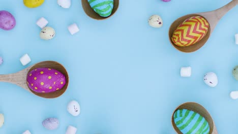 Top-Down-Shot-of-Rotating-Easter-Eggs-In-Wooden-Spoons-with-Confectionary