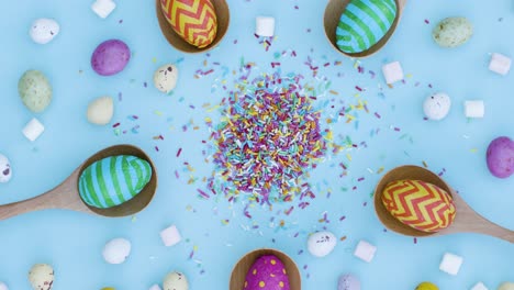 Ascending-Top-Down-Shot-of-Rotating-Easter-Eggs-In-Wooden-Spoons-with-Confectionary