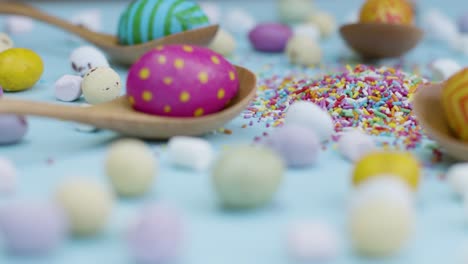 Close-Up-Shot-of-Rotating-Easter-Eggs-In-Wooden-Spoons-with-Confectionary