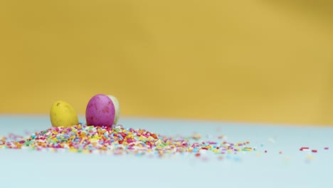 Close-Up-Shot-of-Rotating-Hundreds-and-Thousands-with-Small-Easter-Eggs