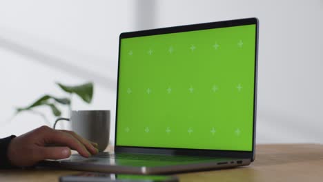 Sliding-Shot-of-Brand-New-MacBook-Pro-On-Desk-with-Green-Screen-02