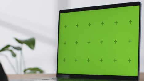 Close-Up-Shot-of-Brand-New-MacBook-Pro-On-Desk-with-Green-Screen