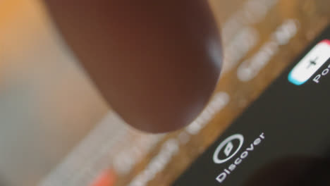 Tracking-Close-Up-of-Finger-Pressing-Tik-Tok-Discover-Button-on-Phone