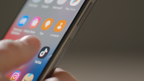 Close-Up-of-Finger-Pushing-Tik-Tok-App-on-Phone