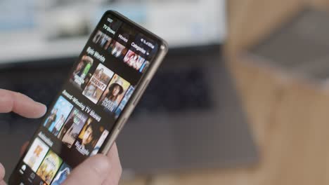Browsing-Netflix-App-on-Phone-at-Desk