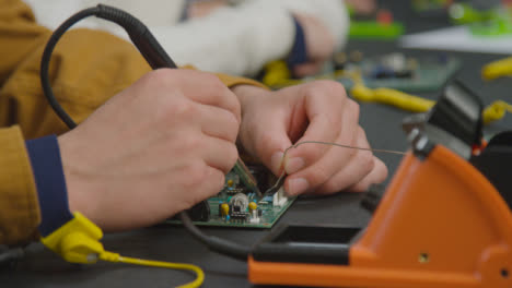 Close-Up-Shot-of-Engineering-Student-Soldering-Circuit-Board-04