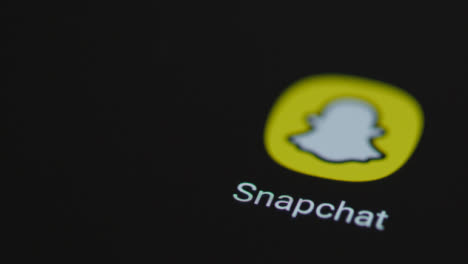 Close-Up-Shot-of-a-Finger-Tapping-Snapchat-On-Smartphone-Screen