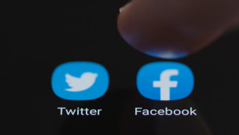 Close-Up-Shot-of-Finger-Tapping-Facebook-App-On-a-Smartphone-Screen