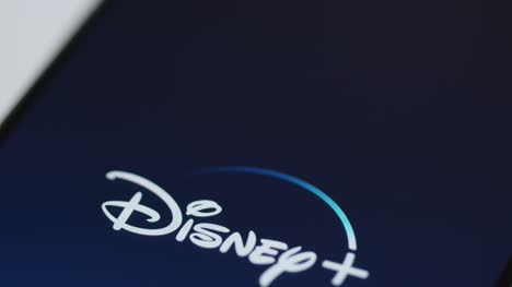 Close-Up-Shot-of-Finger-Tapping-Disney-Plus-On-a-Smartphone-Screen