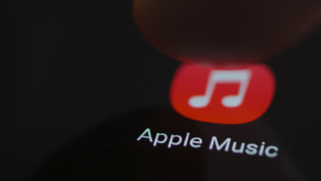 Close-Up-Shot-of-a-Finger-Tapping-Apple-Music-On-Smartphone-Screen