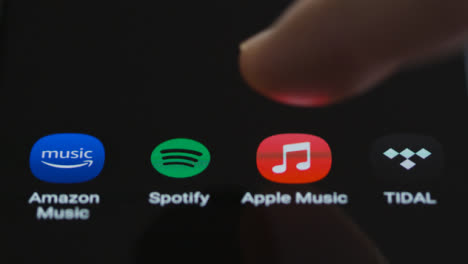 Close-Up-Shot-of-Finger-Tapping-Apple-Music-On-a-Smartphone-Screen