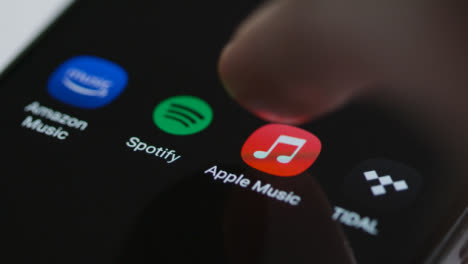 Close-Up-Shot-of-a-Finger-Tapping-Apple-Music-On-a-Smartphone-Touch-Screen