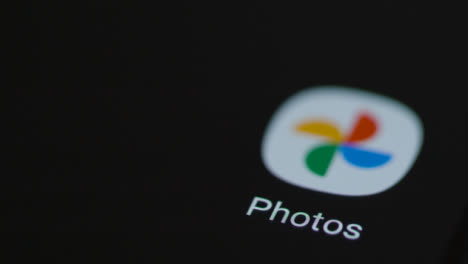Close-Up-Shot-of-Finger-Tapping-the-Google-Photos-App-On-a-Smartphone