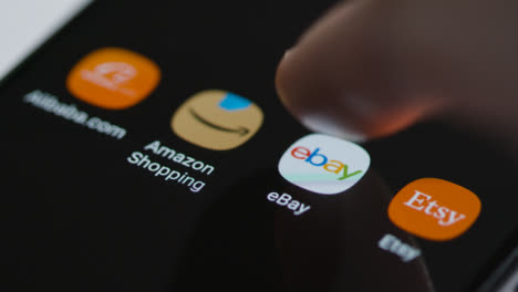 Close-Up-Shot-of-Finger-Tapping-the-Ebay-App-On-Smartphone