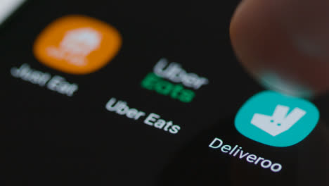 Close-Up-Shot-of-a-Finger-Tapping-the-Deliveroo-App-On-Smartphone-