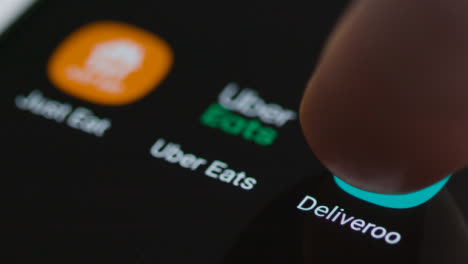 Close-Up-Shot-of-a-Finger-Tapping-the-Deliveroo-App-On-a-Smartphone-