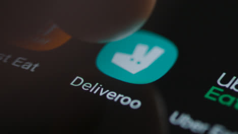 Close-Up-Shot-of-a-Finger-Tapping-the-Deliveroo-App-On-a-Smartphone-Screen
