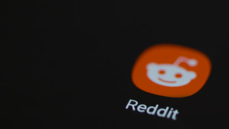Close-Up-Shot-of-Finger-Tapping-the-Reddit-App-On-Smartphone-Screen