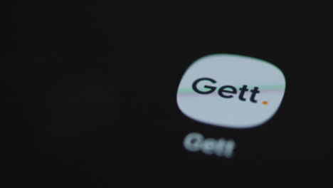 Close-Up-Shot-of-Finger-Tapping-the-Gett-App-On-a-Smartphone-Screen