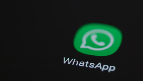 Close-Up-Shot-of-a-Finger-Tapping-the-WhatsApp-Application-On-Smartphone-Screen