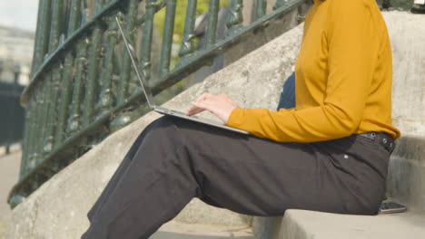 Medium-Shot-of-Young-Man-Joining-Woman-with-Laptop-On-Steps
