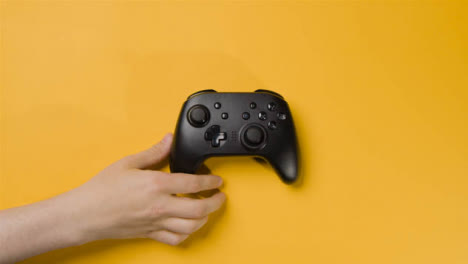 Overhead-Studio-Shot-Of-Hand-Reaching-In-To-Pick-Up-Video-Game-Controller-5