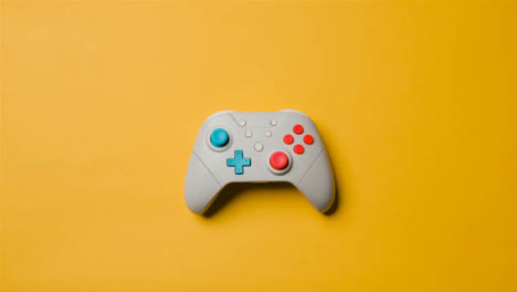 Overhead-Studio-Shot-Of-Hand-Reaching-In-To-Pick-Up-Video-Game-Controller-8