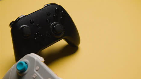 Studio-Close-Up-Of-Two-Video-Game-Controllers-On-Yellow-Background-1