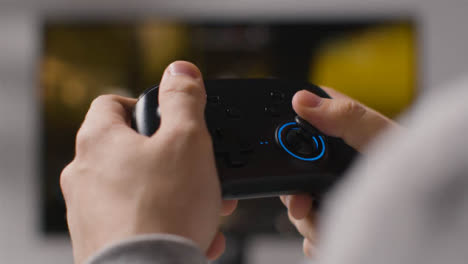 Close-Up-Hands-As-Man-Plays-With-Video-Game-Controller-Screen-In-Background-2