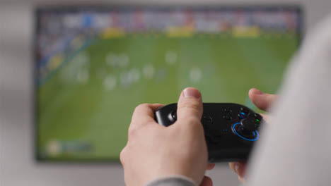 Close-Up-Hands-Man-Playing-Sports-Video-Game-Controller-Screen-Background