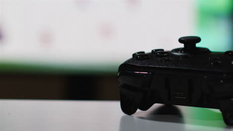 Close-Up-Shot-Of-Video-Game-Controller-Sports-Game-On-Screen-In-Background