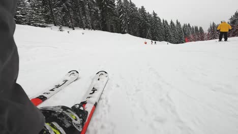 Low-angle-POV-Shot-Of-Skier-Skiing-Down-Misty-Snow-Covered-Slope