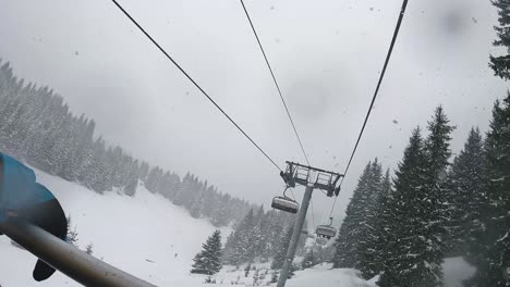 POV-Shot-Of-Skier-On-Chair-Lift-Across-Snow-Covered-Mountain-And-Trees-2