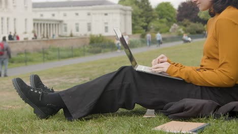 Handheld-Shot-of-Young-Woman-On-Laptop-In-a-Park